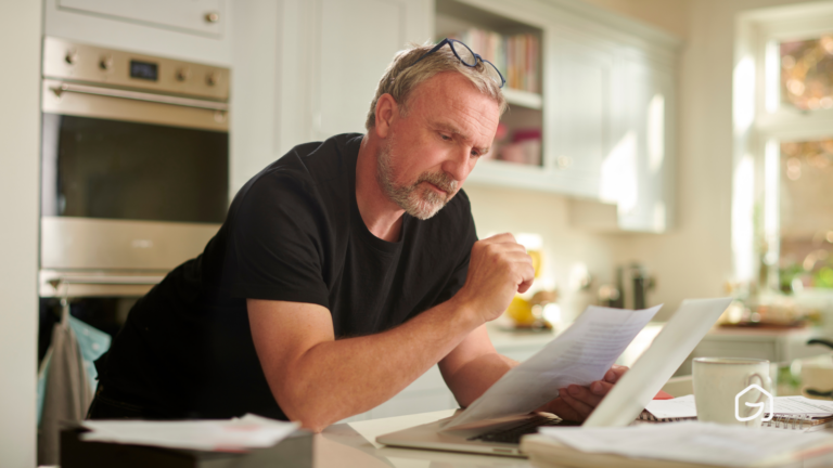 homme dans une maison lisant un dociment papier